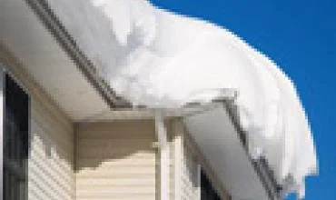 Gausiai sningant draudikai primena valyti ir pastatų stogus